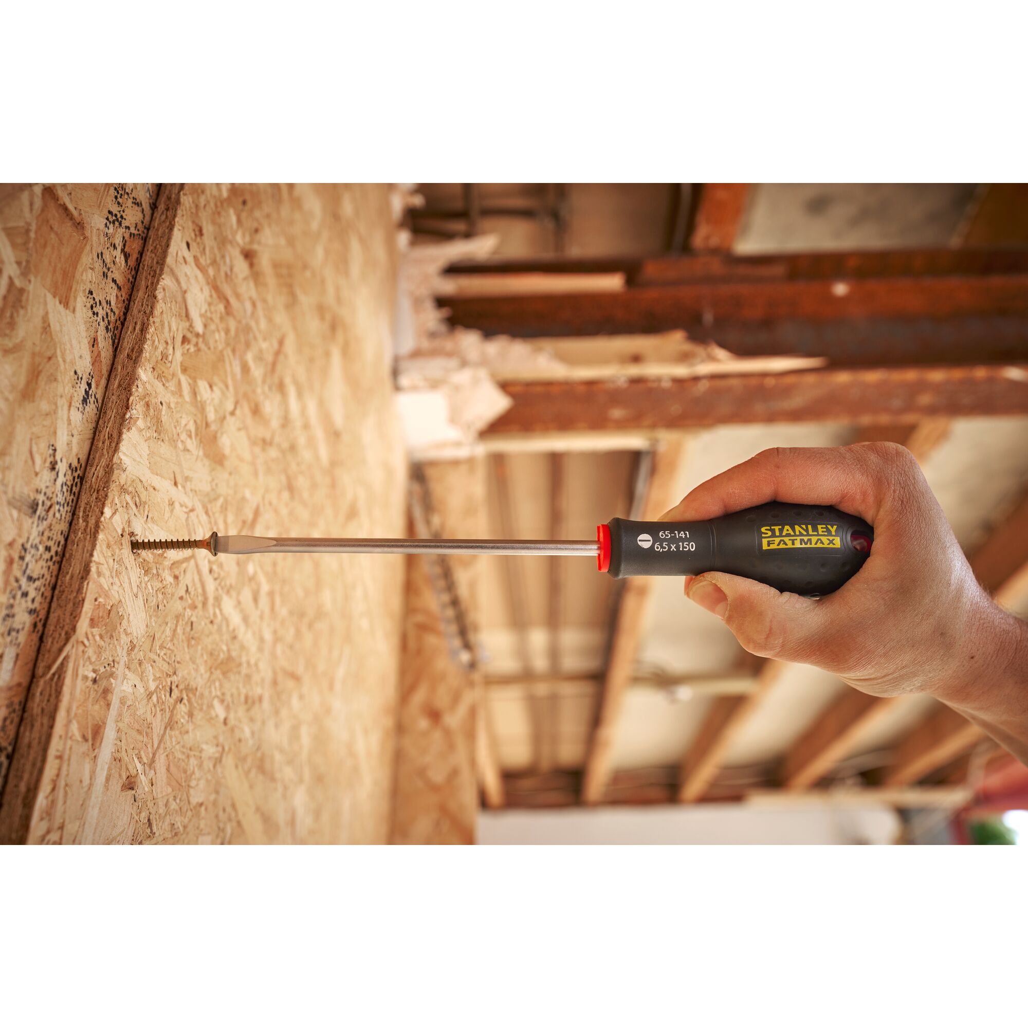 Photo of STANLEY 0-65-141 screwdriver being used to drive a screw into plywood, close-up on handle and tool.