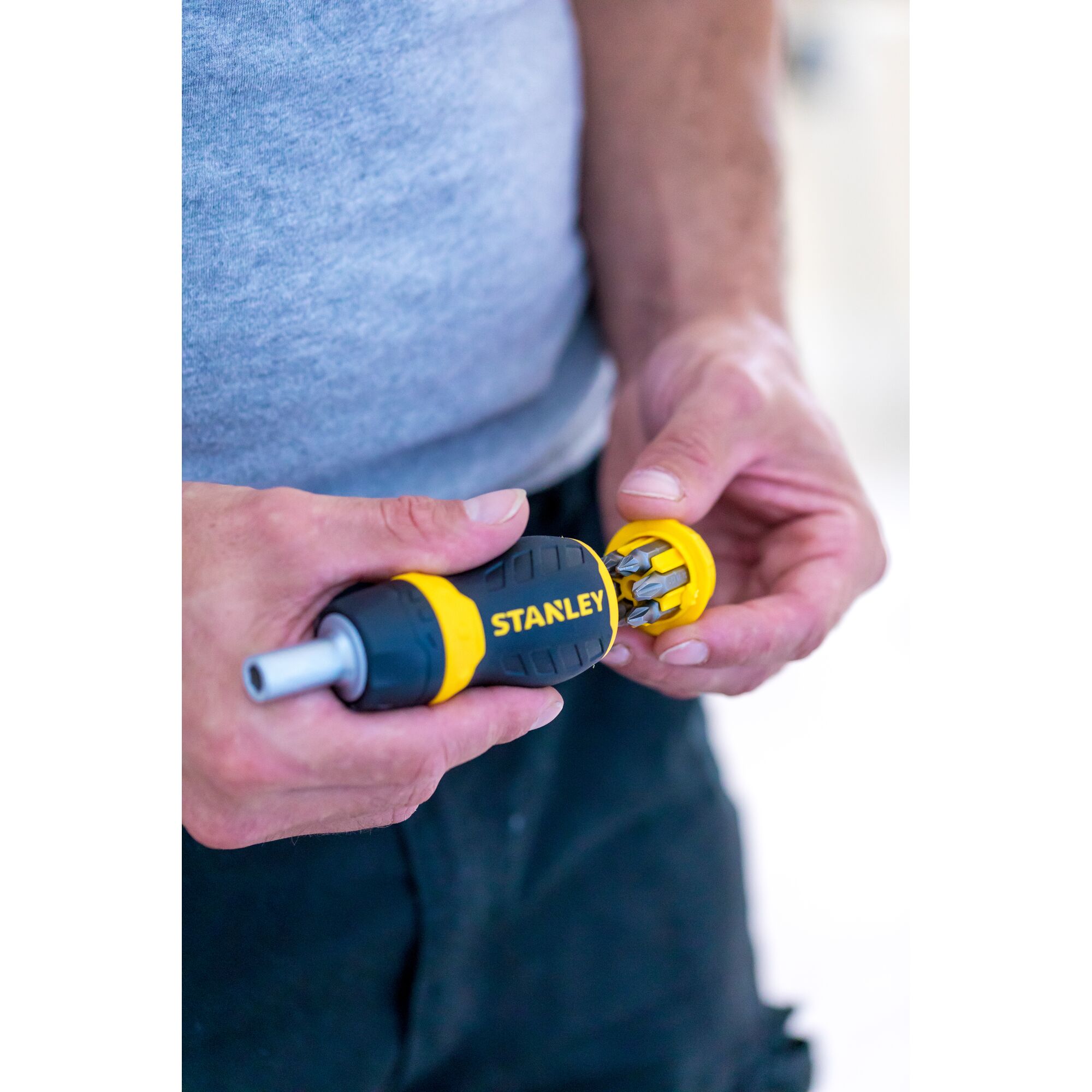 Photo of STANLEY 0-66-358 screwdriver with yellow and black handle showing bit storage in use.