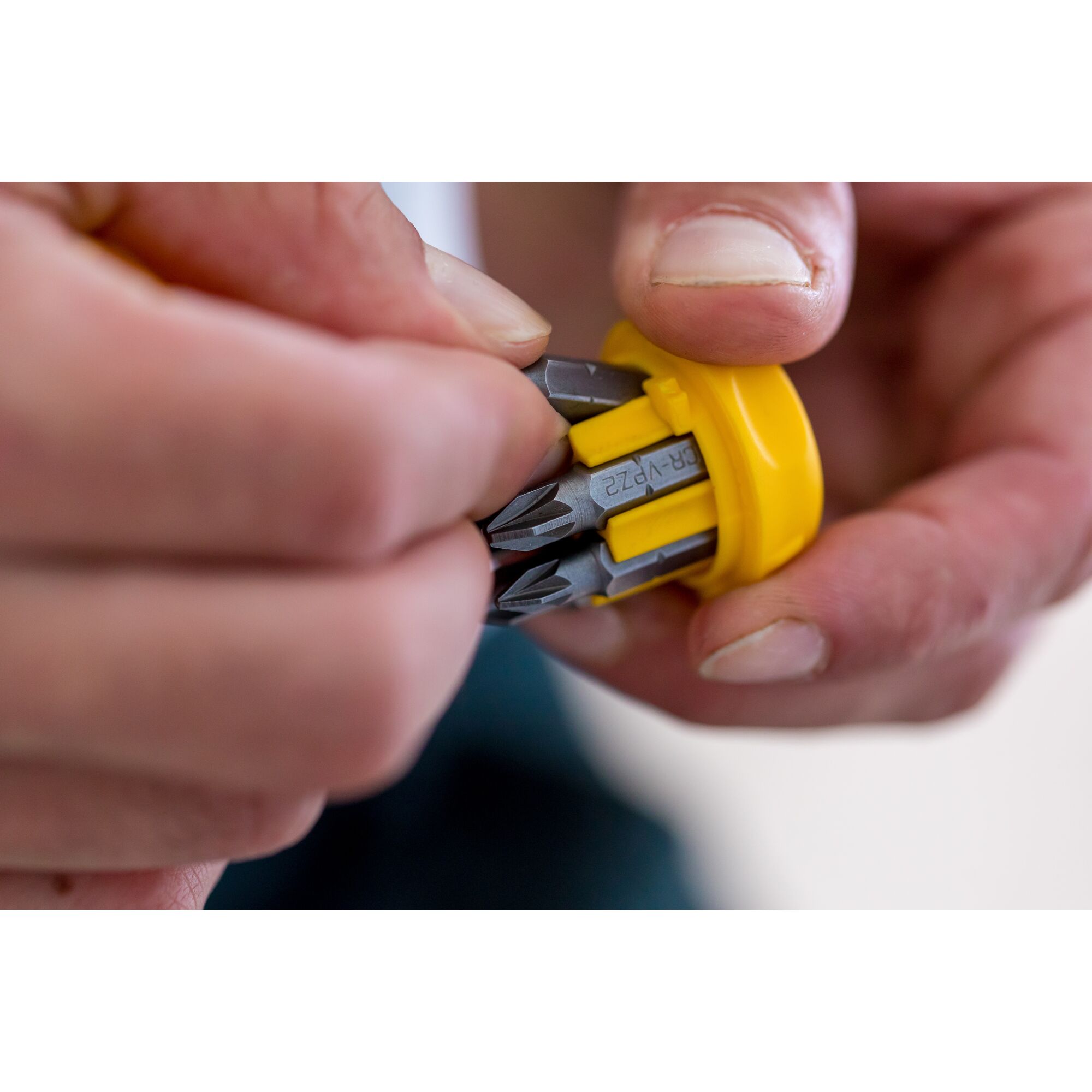 Stanley 0-66-358 screwdriver bits in yellow holder, close-up view of hand selecting bit.