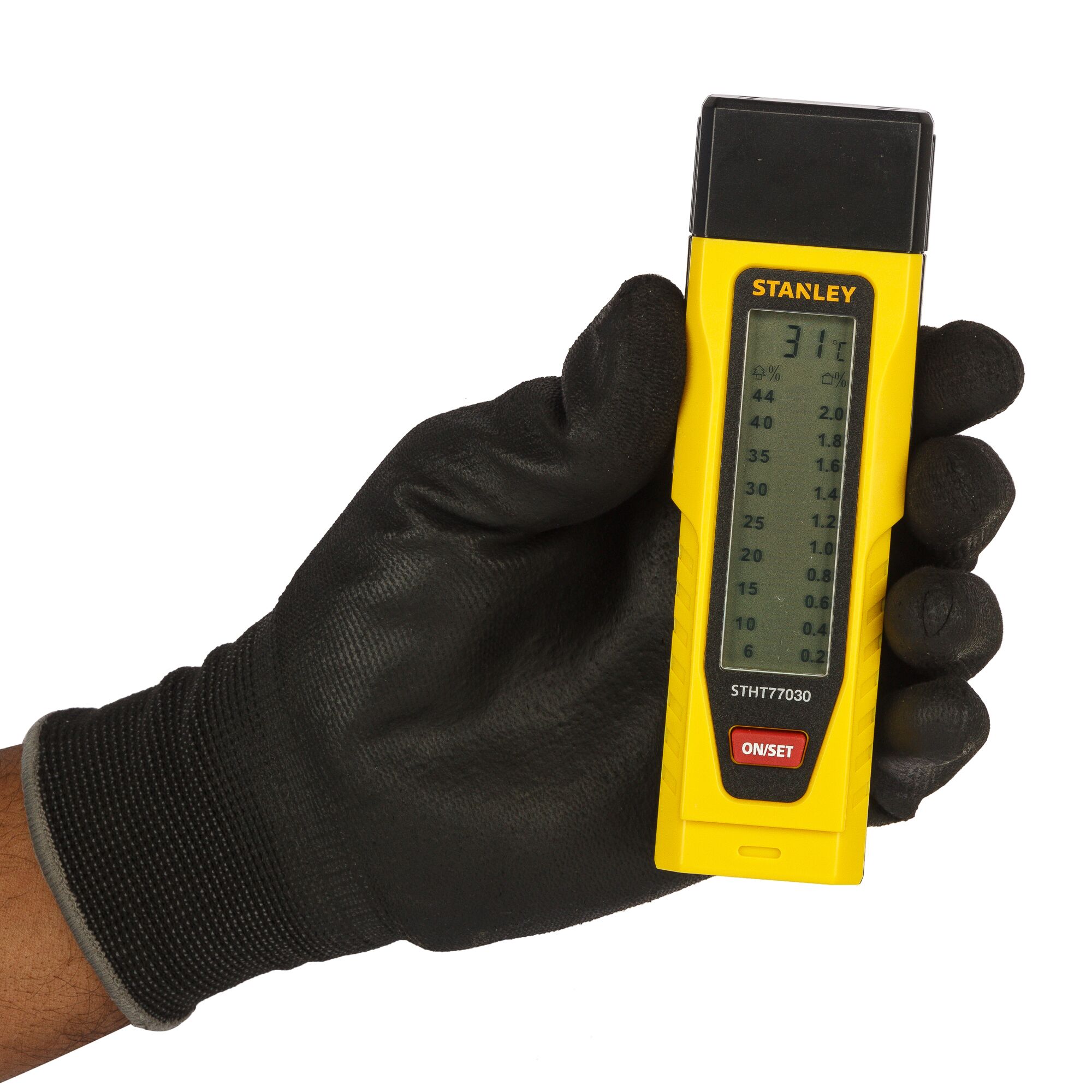 Stanley STHT77030 moisture meter held in a gloved hand, digital display visible.