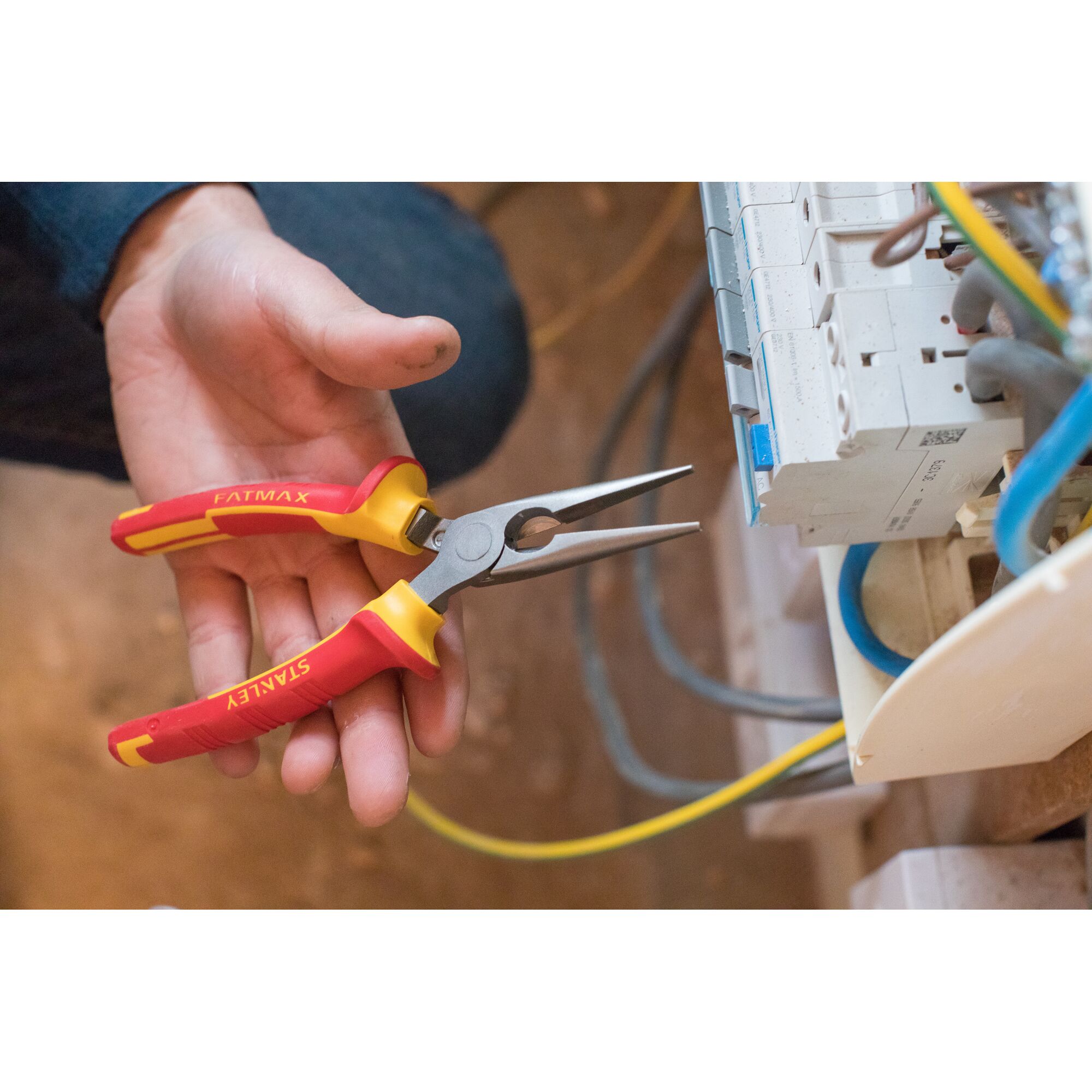 STANLEY 0-84-006 long nose pliers with red and yellow handle held near electrical panel.