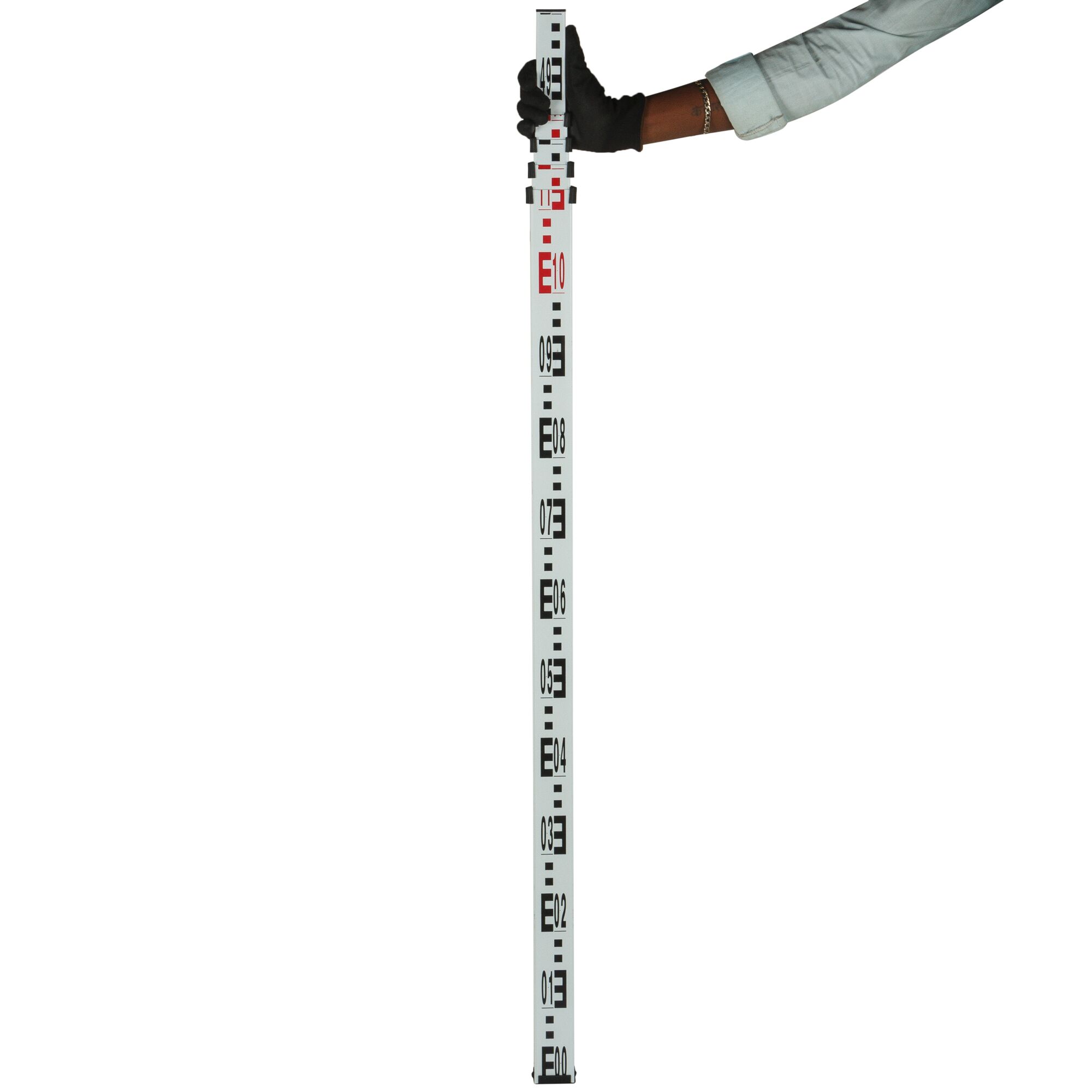 Person holding a STANLEY leveling staff with black and red measurements for surveying and photography.