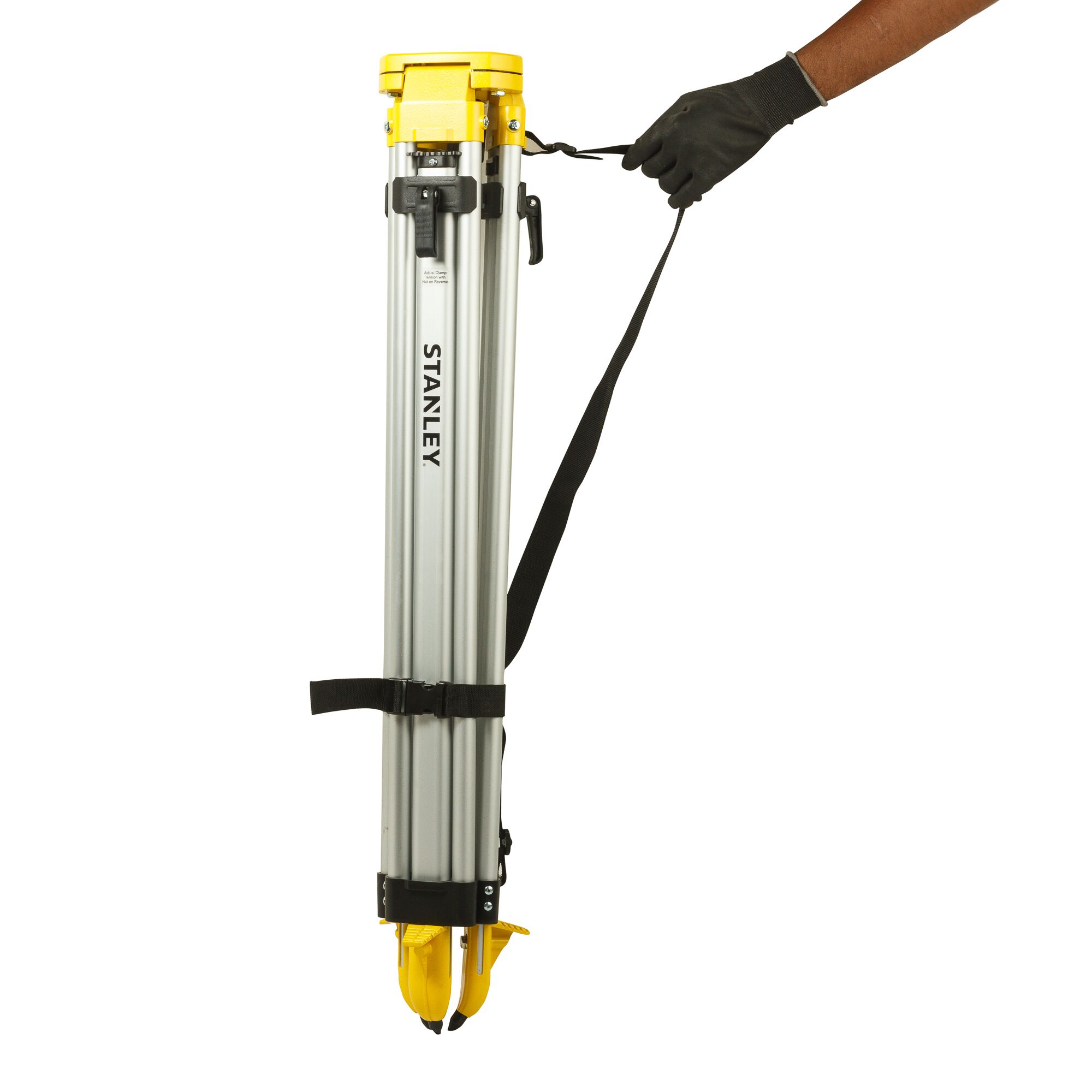 STANLEY 1-77-163 photography tripod folded, silver and yellow, side angle, carried by hand with black strap.