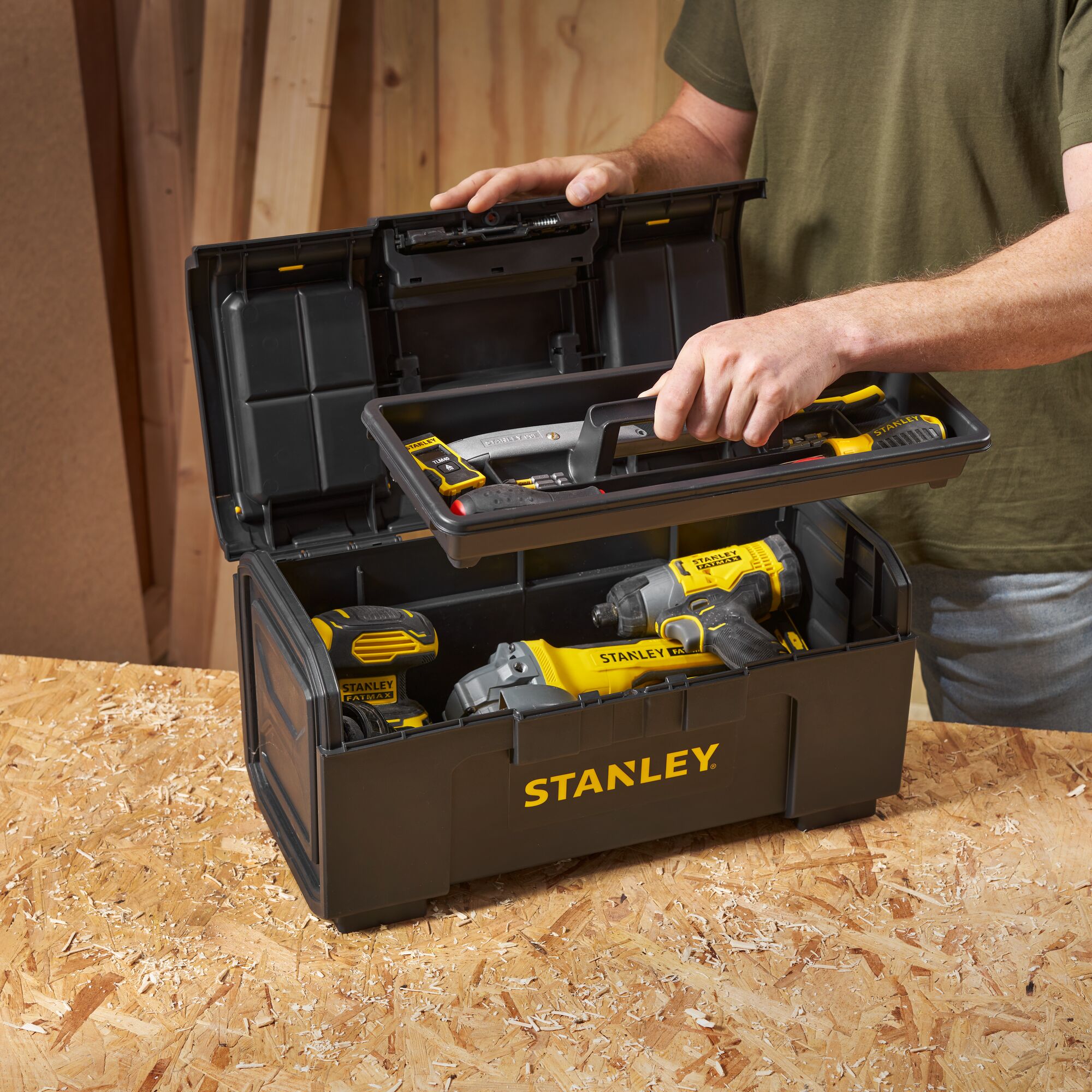 STANLEY 1-79-217 toolbox with yellow and black power tools, open on workbench, angled view.