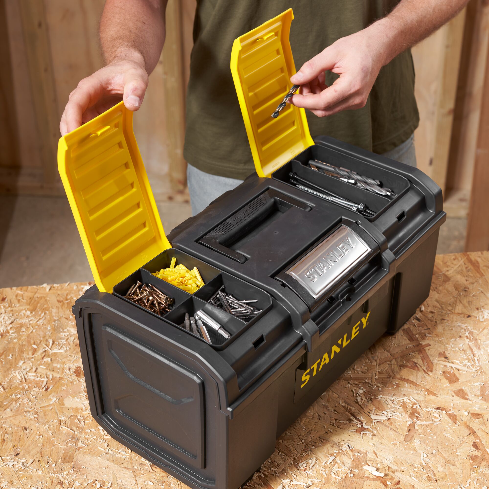 STANLEY 1-79-217 black toolbox with yellow lids, open to show compartments with screws and drill bits.