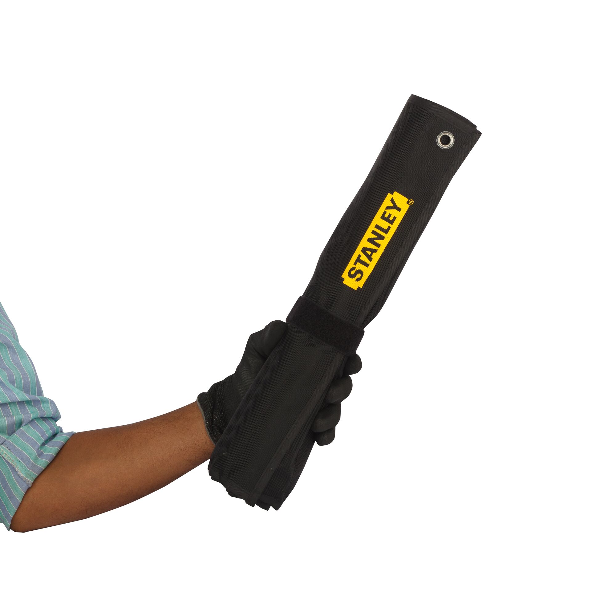 Hand holding folded black Stanley photography accessory with yellow logo and Velcro strap.