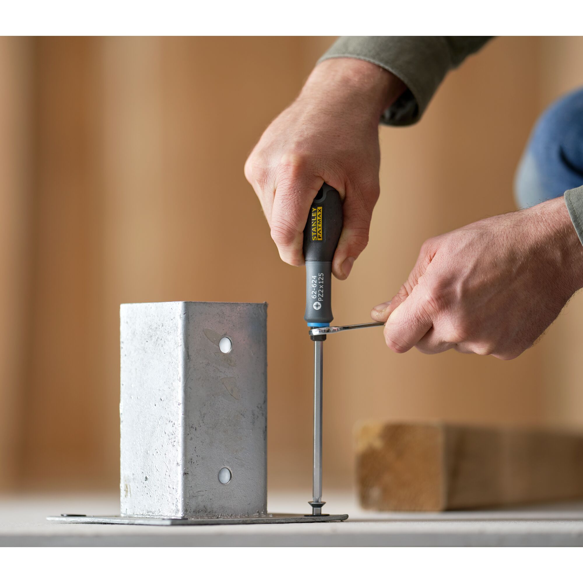 Photo of STANLEY FMHT0-62624 screwdriver being used to fasten a screw into a metal bracket on a flat surface.