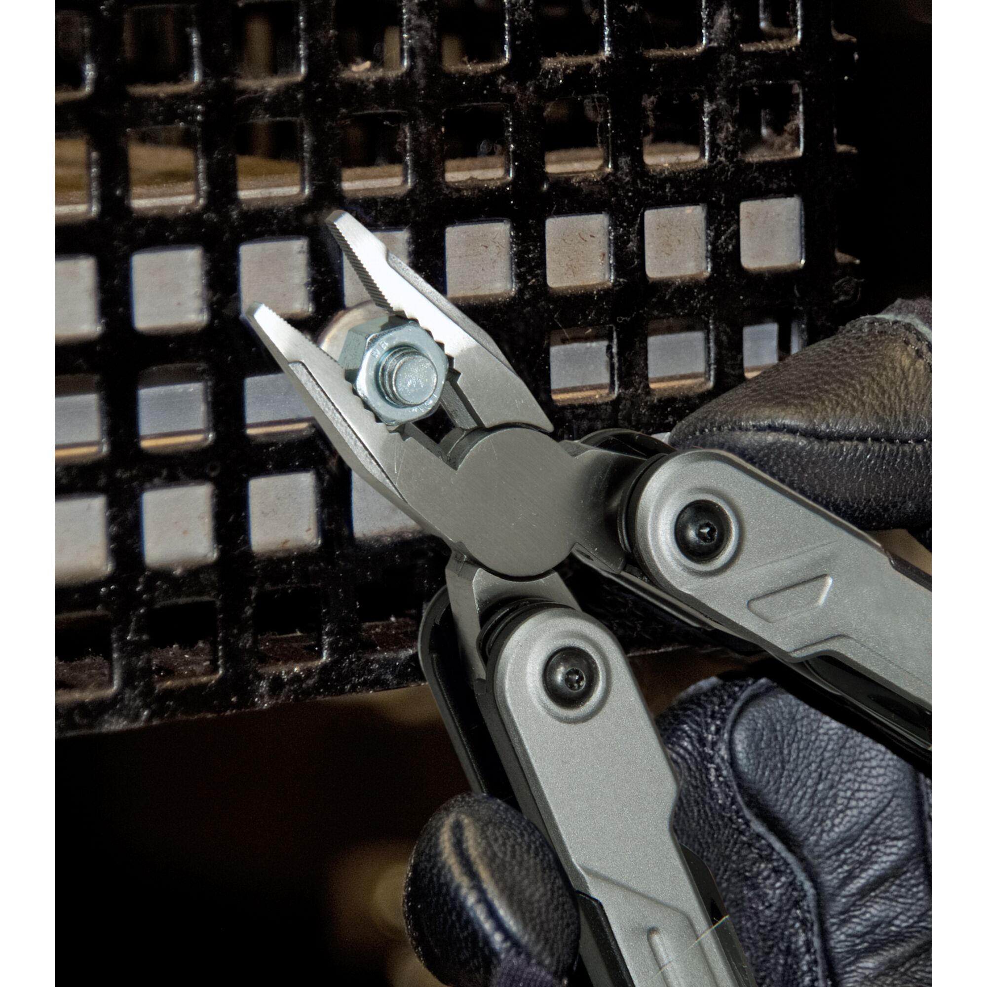 STANLEY FMHT0-72414 multi-tool pliers gripping a bolt, close-up view with gloved hand.