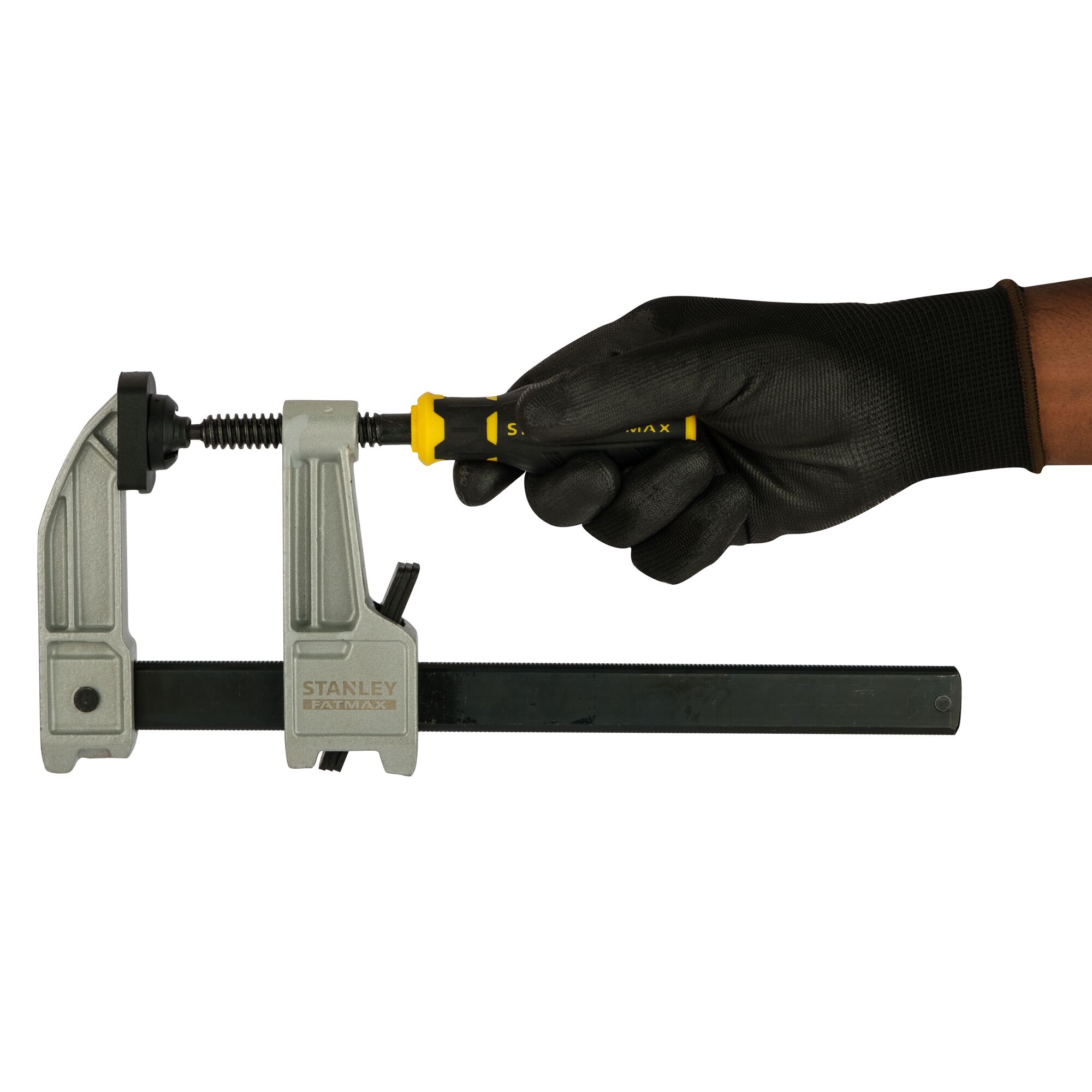Photo of STANLEY FMHT0-83244 bar clamp with black-gloved hand tightening handle, front angle.
