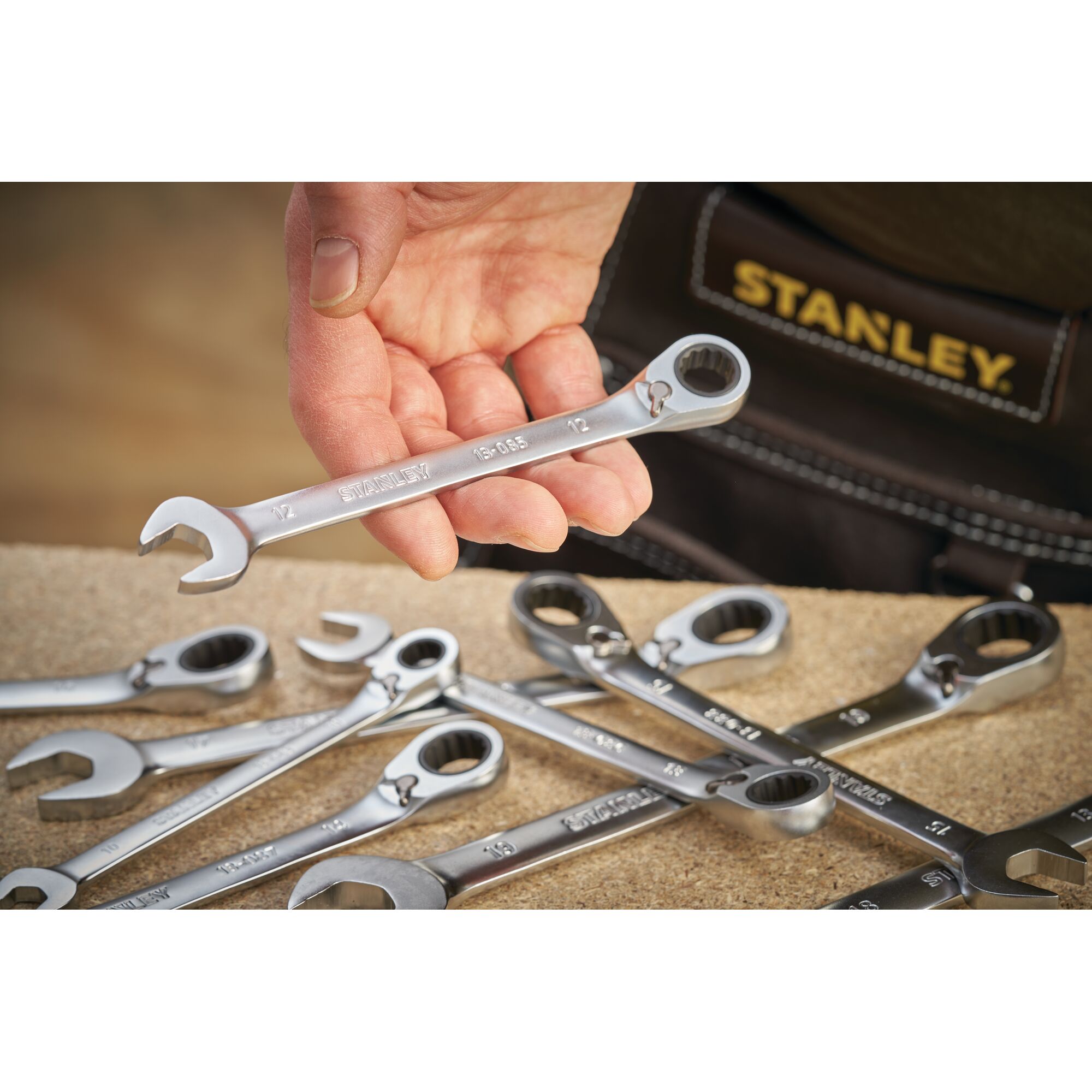 Photo of STANLEY FMMT13083-0 ratcheting combination wrenches on a workbench, one held in hand, brand name visible.