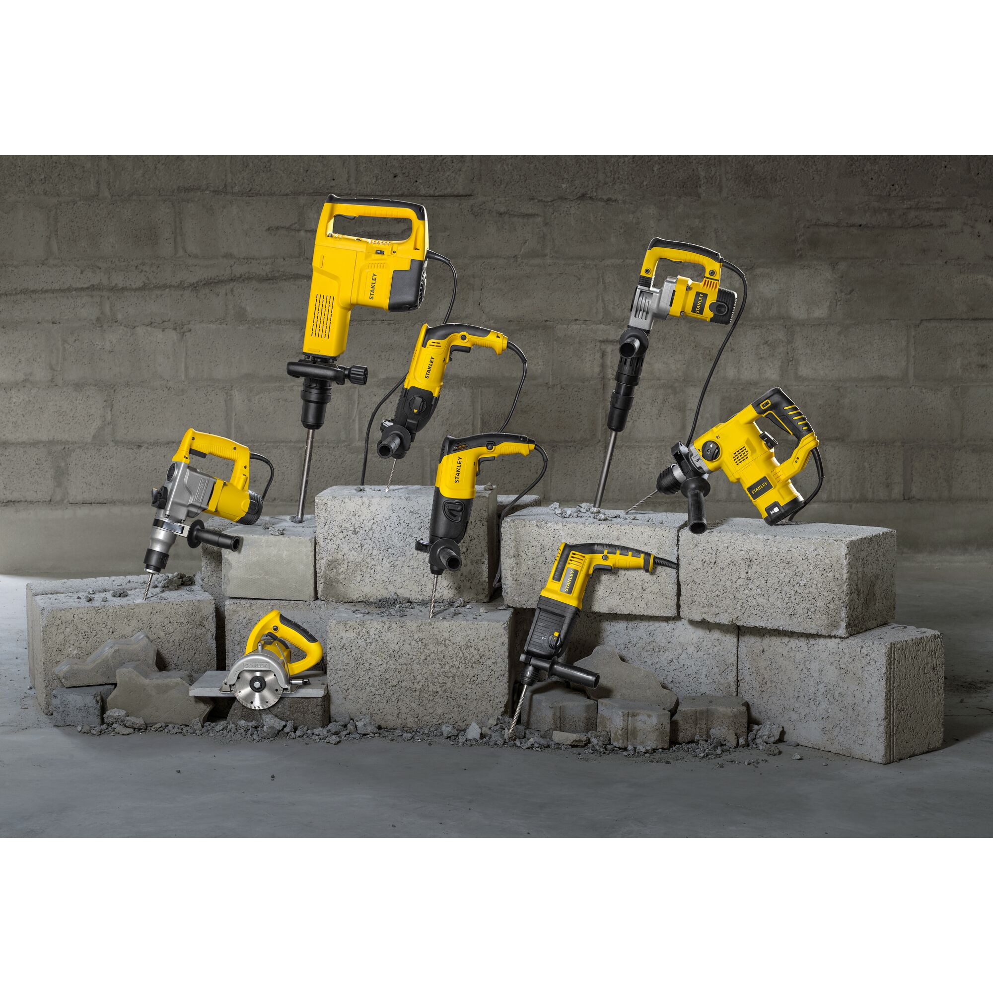 STANLEY SHR263K-BR rotary hammers and drills displayed on concrete blocks, front angle.