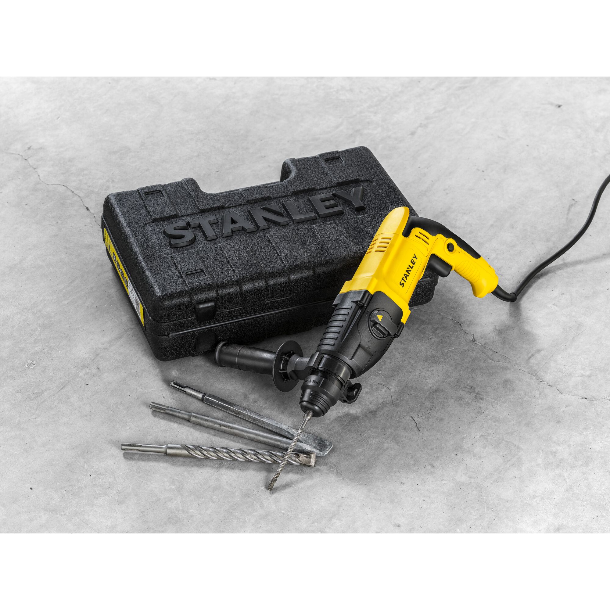 Stanley SHR263K-BR corded rotary hammer with drill bits and black carrying case on concrete.