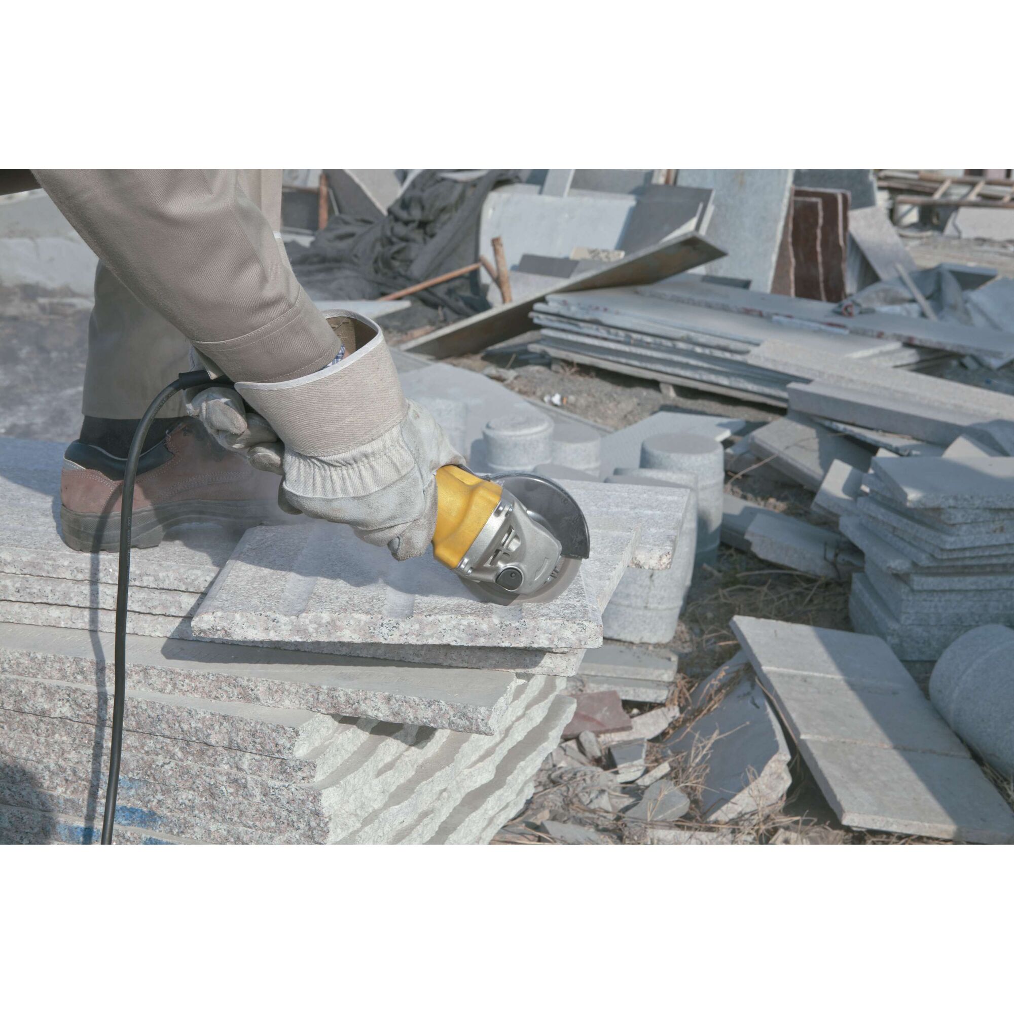 Stanley STGS9125 angle grinder used on stone slab outdoors, close-up showing tool in action.