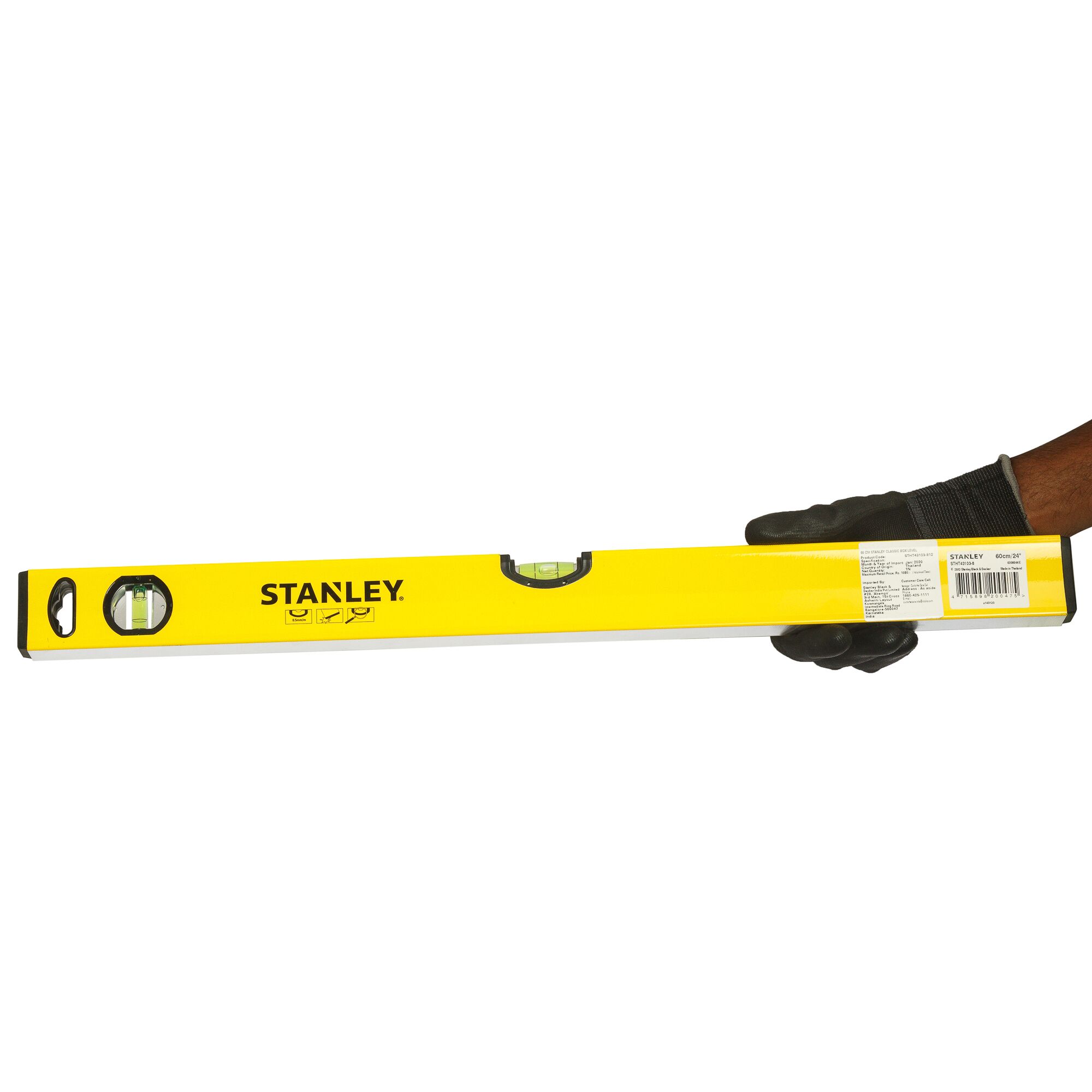 Stanley STHT43103-812 yellow spirit level held by gloved hand, side angle, product photography.