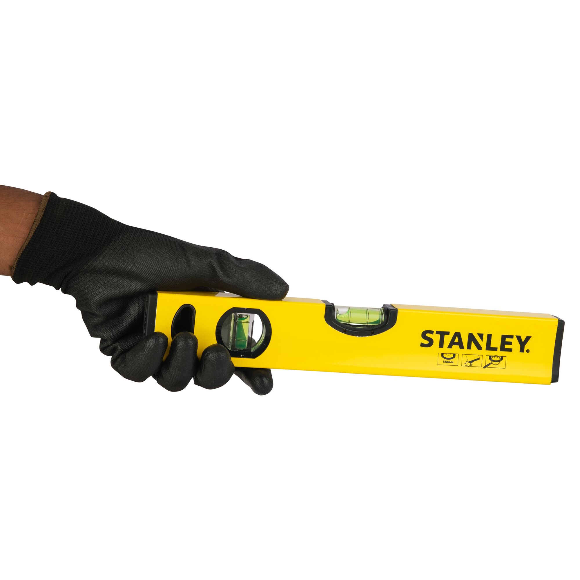 Photo of STANLEY STHT43118-812 yellow spirit level held by gloved hand, front angle on white background.