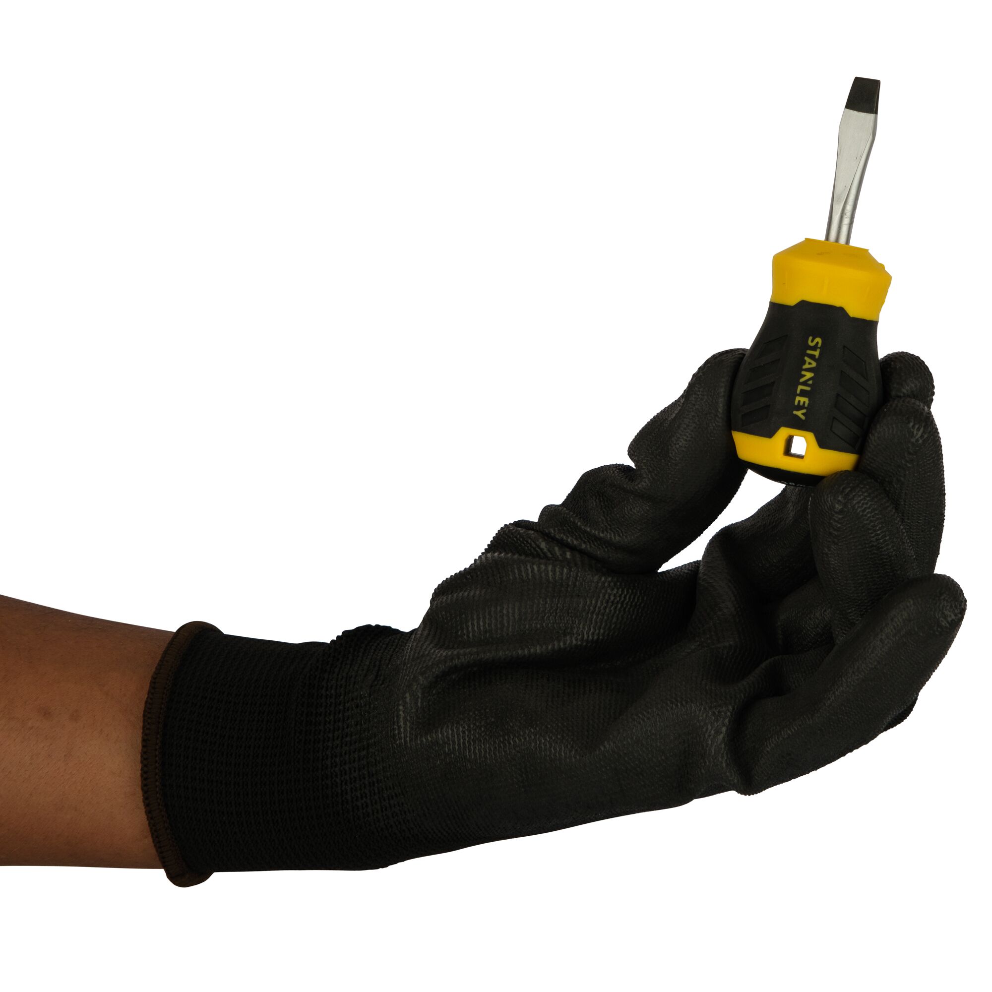 Hand in black glove holding a Stanley stubby flathead screwdriver with yellow and black handle.