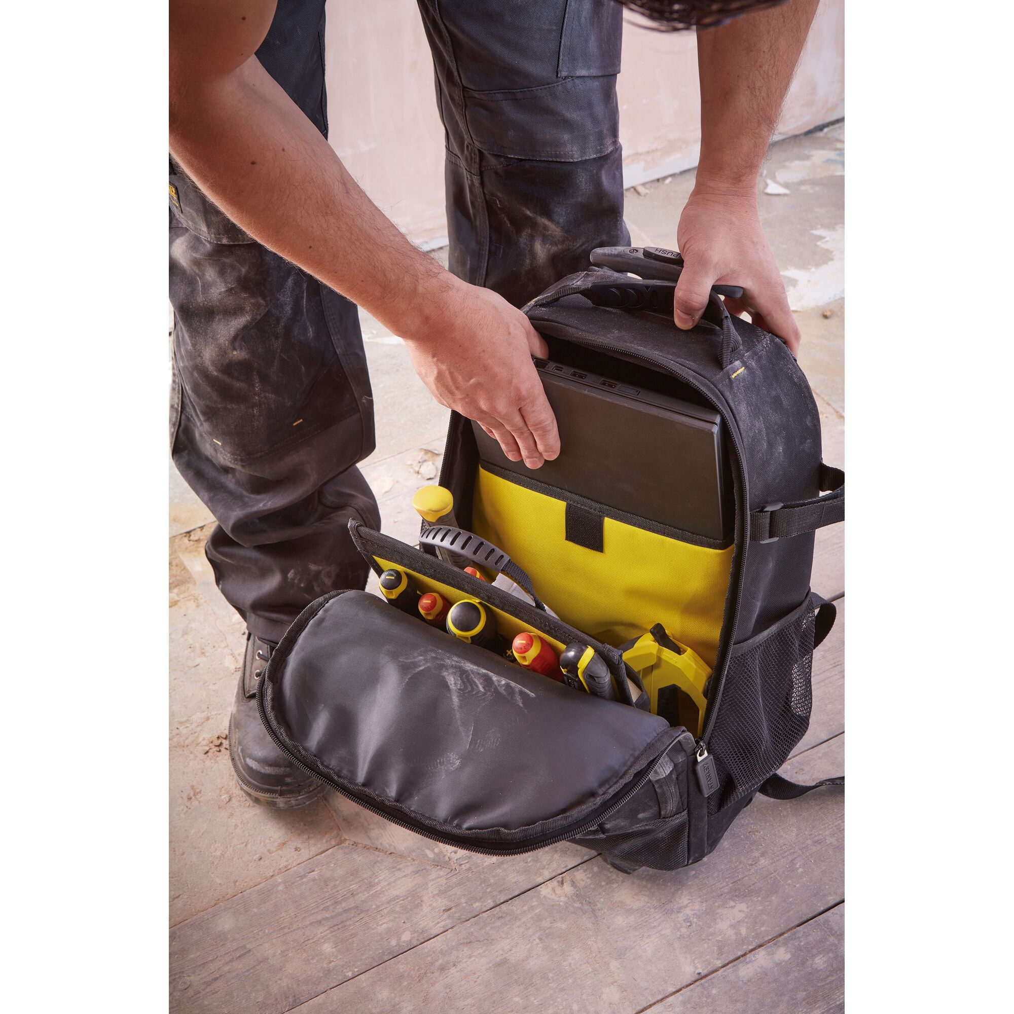 STANLEY STST83307-1 tool backpack with yellow interior, open front shows tools and tablet storage.